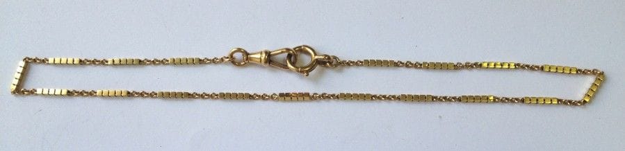 Chaine giletière en or 18K (750‰), maille bâtonnet. 
Poids : 10,5 g