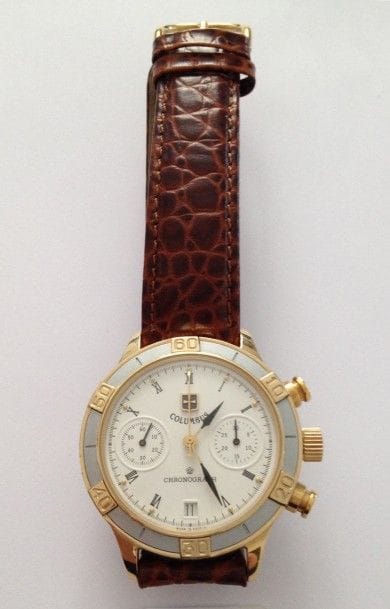 COLUMBUS. 
Montre bracelet d’homme, chronograph, en métal doré, cadran blanc chiffres romains, date à 6H. Compteur de minutes à 3H, trotteuse à 9H, bague extérieure argentée, fonctionne. 