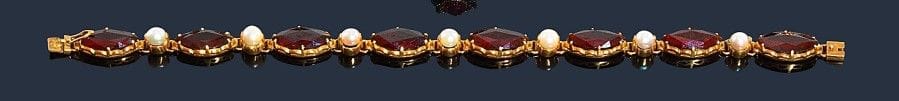 Bracelet en or jaune 18K (750‰), orné de grenats fusiformes alternés de petites perles. Poids brut : 12,8 g