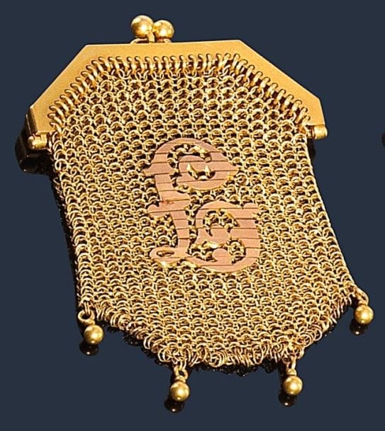 Petite bourse en cote de mailles d’or jaune 18K (750‰) tricoté, appliquée d’un chiffre, terminée de trois billes d’or. Travail français des années 1900. 
Poids : 30,2 g 
(accroc)