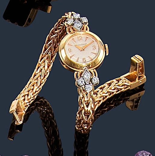 JAEGER-LECOULTRE.
Montre de dame en or jaune 18K (750‰), cadran rond, fond crème, index bâtons et chiffres arabes, les attaches agrémentées de diamants, bracelet en tresse d’or jaune, mouvement mécanique. Numérotée 131598. 
Longueur : 19,5 cm environ. Poids brut : 46,8 g
