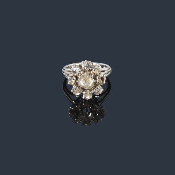 Bague en fils d’or gris 18K (750‰), ornée de 9 diamants taillés en roses, celui du centre plus important. 
Tour de doigt : 53/54. Poids brut : 5,6 g