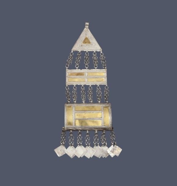 Ornement de tête, hirz qafa, Sultanat d’Oman, XXe siècle
Parure tripartite en métal doré et argenté formée d’un porte-coran à breloques géométriques, surmonté d’une plaque rectangulaire et d’une plaque triangulaire, unies par cinq paires de chaînettes. 
Dim. : 25.5 cm
État: petites restaurations.
Pour un exemple similaire, voir vente publique Ader, expert Marie-Christine David, Arts de l’Islam et de l’Inde, 25 novembre 2013, Paris, Hôtel Drouot, lot 167.
A head ornament, hirz qafa, Oman, 20th century