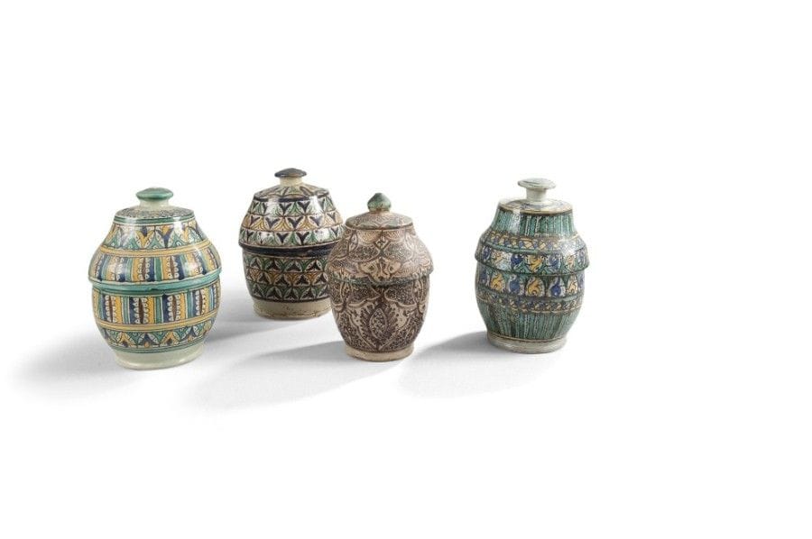 Quatre pots à beurre jobbana, Fès, fin XIXe siècle
Faïences polychromes jaune, bleu, vert, brun à panse sphérique et couvercle à bouton à décor pour le premier, dit de « mille-pattes » encadrant deux bandeaux de palmettes bleues et jaunes dans des arches vertes ;-le second, de deux registres verticaux de fleurs stylisées ;-le troisième, de registres de tulipes stylisées tête-bêche bleues, jaunes et vertes ;-le quatrième, de médaillons polylobés entrelacés meublés de points, de croisillons et de fleurs stylisées, haut du couvercle festonné de vert. 
Haut. : 27,5 cm, diam. : 17,5 cm ; haut. : 25 cm, diam. : 17,5 cm ; haut. : 27.5 cm, diam.: 17.3 cm ; haut. : 25 cm, diam. : 15,5 cm
État : éclats, fêlures, pour le premier manque au couvercle ; pour le quatrième, couvercle disparate et manque
Four polychrome pottery butter pots, Jobbana, Morocco, Fez, late 19th century