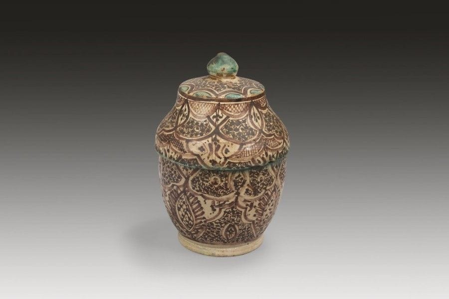 Trois pots à beurre jobbana, Fès, fin XIXe siècle
Faïences polychromes jaune, bleu, vert, brun à panse sphérique et couvercle à bouton. Le premier, à décor dit de « mille-pattes » encadrant deux bandeaux de fleurs à pétales jaunes et cœur vert sur fond de points bleus ;-le second, registre de losanges à fleurs stylisées sur fond de points bleus bordés de deux bandeaux festonnés verts ;-le troisième, orné de deux compartiments de tulipes stylisées et de deux registres de triangles bleus ou jaunes meublés de points bleus.
Haut. : 29,5 cm, diam. : 20 cm ; haut. : 22 cm, diam. : 17 cm ; haut. : 28,5 cm, diam. : 18.5 cm
État : éclats, rebuts de cuisson collés ; pour le second, manque au bord du couvercle ; pour le troisième, manque au bouton, couvercle et intérieur.
Three polychrome pottery butter pots, Jobbana, Morocco, Fez, late 19th century