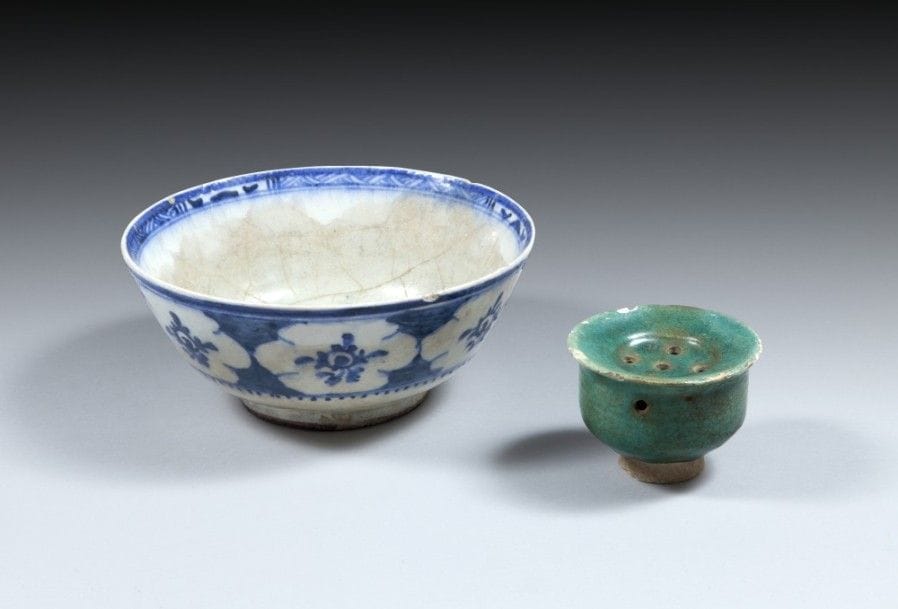Soupoudreur et coupe, Iran, XIIIe et XIXe siècle
Soupoudreur en céramique à glaçure vert turquoise sur petit piédouche ;-coupe à panse hémisphérique sur base circulaire, en céramique peinte en bleu sur fond blanc de fleurs bleues dans des médaillons. Date 1278H. / 1861 à la base.
Soupoudreur diam. : 10, 5 cm, haut. : 8 cm ; coupe diam. : 23,7 cm, haut. : 10,3 cm 
État : soupoudreur : éclats et manques ; coupe : glaçure craquelée et taches
A pottery sprinkler and a bowl, Iran , 13th and 19th century