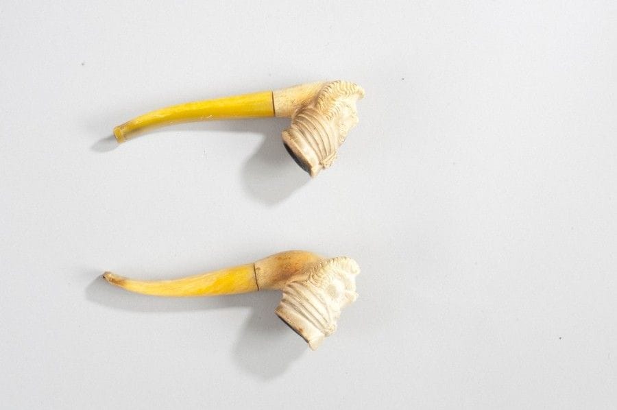 Deux pipes à têtes enturbannées, Europe, XIXe siècle 
Tuyau en ambre et fourneau en écume sculptée d’une tête orientale à large barbe coiffée d’un turban à aigrette. 
Long. : 14,2 cm ; 13,6 cm
État : extrémité de l’embout ébréchée pour l’une. 
Two pipes with turbaned heads, Europe, 19th century 