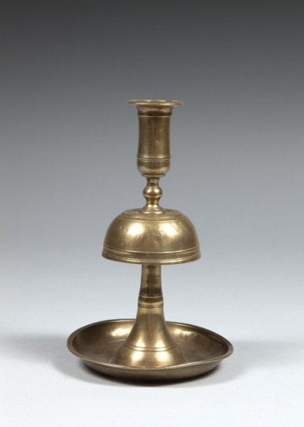 Bougeoir en laiton, Proche-Orient, début XXe siècle
Bougeoir à long binet en laiton à partie centrale en cloche sur base circulaire 
H. : 20,6 cm
État : parties légèrement enfoncées.
Brass candlestick, Near East, early 20th century
