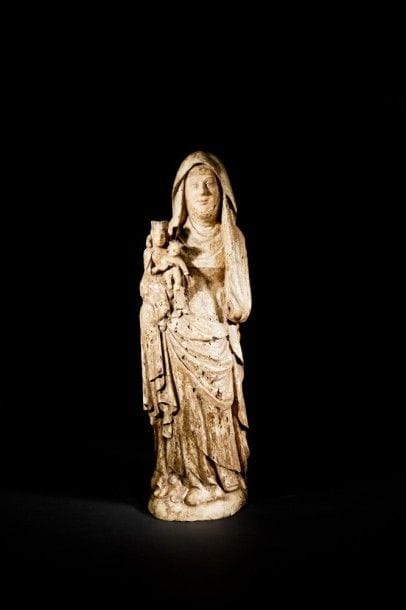 Sainte Anne Trinitaire en noyer sculpté en ronde-bosse, polychromé et doré. Debout, elle porte Marie et Jésus sur son bras droit ; beau visage ovale encadré d’une guimpe ; elle est vêtue d’une robe et d’un long voile formant manteau..
Espagne, fin du XIVe siècle.
Hauteur : 85 cm.
(quelques vermoulures et manques dont la main gauche).
