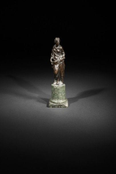 Figure féminine en bronze à patine brune ; reposant sur une base circulaire en marbre vert (éclats)..
Début du XVIIe siècle..
H : 30 cm.
