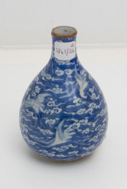7845/326 Chine
Petit vase piriforme en porcelaine à décor en bleu sous couverte de grues parmi des nuages sur fond bleu.
XIXe siècle. 
Hauteur: 11 cm.
Col rodé.
