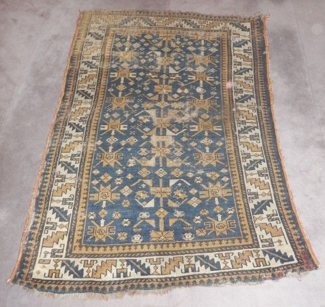 Tapis caucasien à motifs géométriques sur fond bleu marine, bordure ivoire entre galons marine et "tête de nègre"
Usé
Début XXe
138 x 100 cm