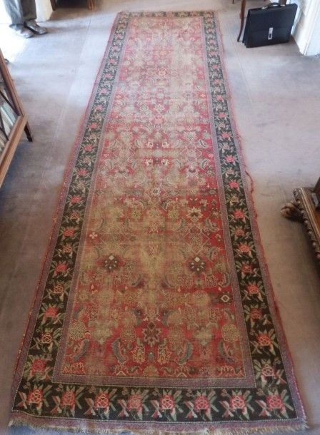 Tapis de galerie à décor herati sur fond vieux rose à bordure noire ornée de roses.
Karabagh, début XXe
400 x 100 cm environ