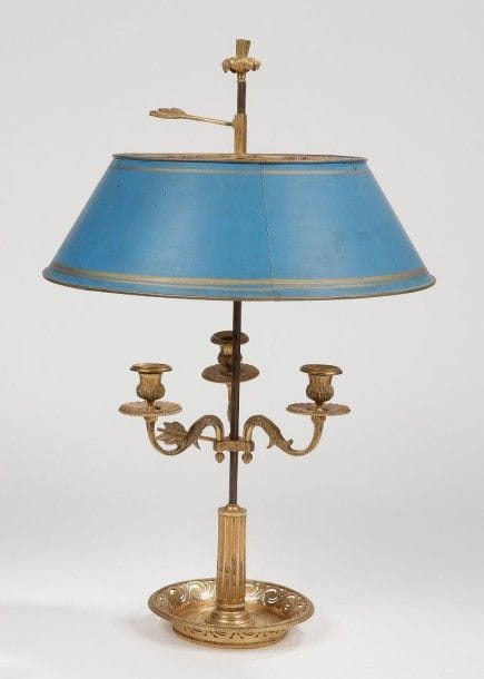 Lampe bouillote en bronze doré à trois lumières sur un fût à crémaillère surmonté d'un abat-jour en tôle peinte en bleu.
Style Louis XVI, XIXe siècle.
H.: 60 cm