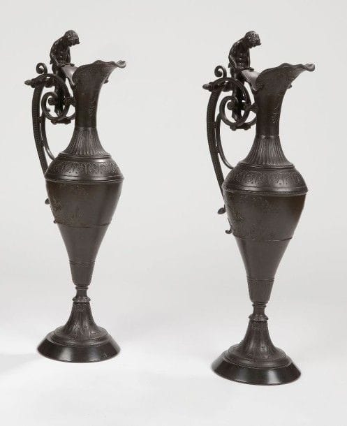 Paire de grandes aiguières en régule patiné dans le goût de la Renaissance, l'anse à figure de satyre, reposant sur un piédouche à base de marbre noir.
Fin du XIXe siècle.
H.: 56 cm
