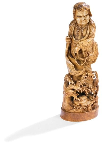 JAPON - Époque MEIJI (1868 - 1912)
Okimono en ivoire à patine jaune, Rakan debout au-dessus des flots tenant un rosaire et un bâton. Signé dans un cartouche en laque rouge Gyokuzan. 
(Accident au bâton). 
Hauteur : 27 cm