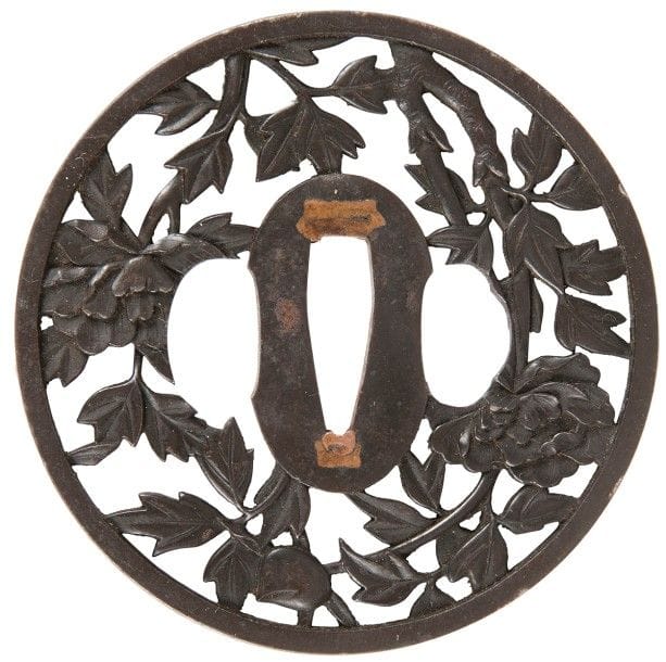 JAPON - Époque EDO (1603 - 1868), XVIIIe-XIXe siècle
Maru gata en fer ajouré en maru bori de pivoines dans leurs feuillages. 
Hauteur : 8,2 cm