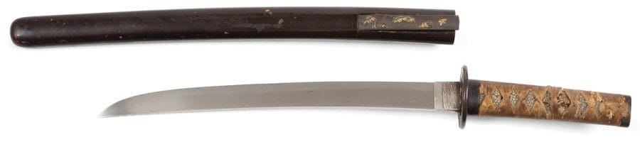 JAPON
Shinshinto wakizashi, shinogi zukuri, hamon notare, deux mekugi ana. Fushi kashira à décor de dragon en katakiri bori, tsuba nagamaru gata en bronze à décor de flots et pagode, menuki figurant des personnages. Saya en laque brun noir. 
(Accidents.)
Longueur : 30,5 cm