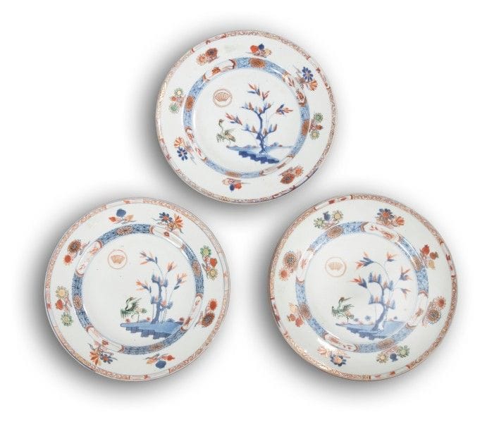 CHINE - Époque KANGXI (1662 - 1722)
Trois assiettes en porcelaine blanche décorées en bleu sous couverte, rouge de fer et émail or d’une grue sous un arbre et mont japonais. 
(Une avec fêlure).