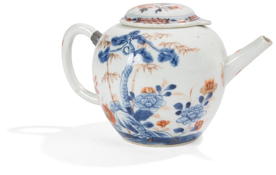 CHINE - XVIIIe siècle
Théière en porcelaine décorée en bleu sous couverte, rouge de fer et émail or de pivoines pins et bambous. Couvercle rapporté de même époque. 
(Éclats intérieurs). 
Hauteur : 13 cm