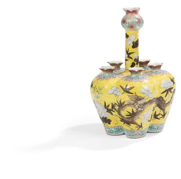 CHINE - Début XXe siècle
Tulipière à cinq pans en porcelaine émaillée polychrome à décor dragons parmi les pivoines et chrysanthèmes, le col se terminant par une grenade. 
(Restaurations au bord et fêlure, égrenure). 
Hauteur : 27 cm