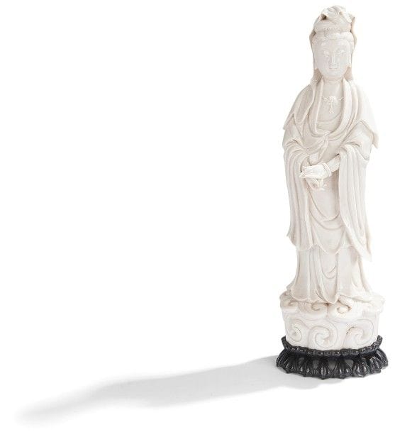 CHINE - XVIIe siècle
Statuette de Guanyin debout sur le lotus en porcelaine blanche, les yeux entre ouverts, les mains jointes. 
Socle en bois. 
Hauteur : 41,4 cm