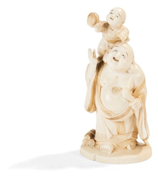 JAPON - Époque MEIJI (1868 - 1912) 
Okimono en ivoire à patine jaune Hotei debout un enfant sur le dos. Signé Munegyoku dans un cartouche en laque rouge. 
Hauteur : 14,2 cm