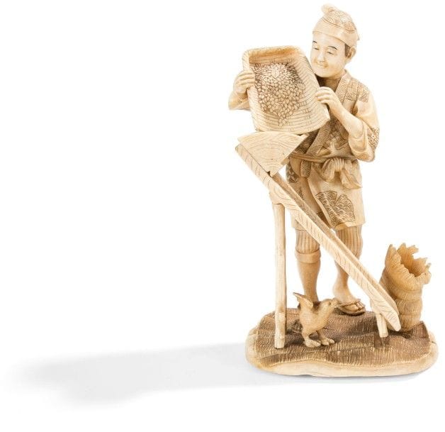 JAPON - Époque MEIJI (1868 - 1912) 
Okimono en ivoire marin à patine jaune, paysan filtrant du grain. Signé Mitsu … dans un cartouche en laque rouge. 
Hauteur : 26 cm