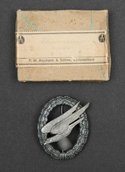 Insigne parachutiste Lwf. (Zinc).
Assmann. I / 64 dans sa boîte F.W. Assmann & Söhne. Lüdenscheid.
10 photos de paras essentiellement en tenues tropicales front italien.
