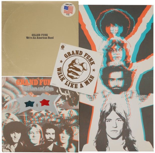 GRAND FUNK 
Lot de deux 33 T «We’re an American band» (1973) et «Shinin’ on» (1975). Label CapItol Édition U.S.A. Inclus l’autocollant, la pochette 3D avec lunette, le poster cartonné et un 45 T.
Pochettes et disques VG++ / EX
