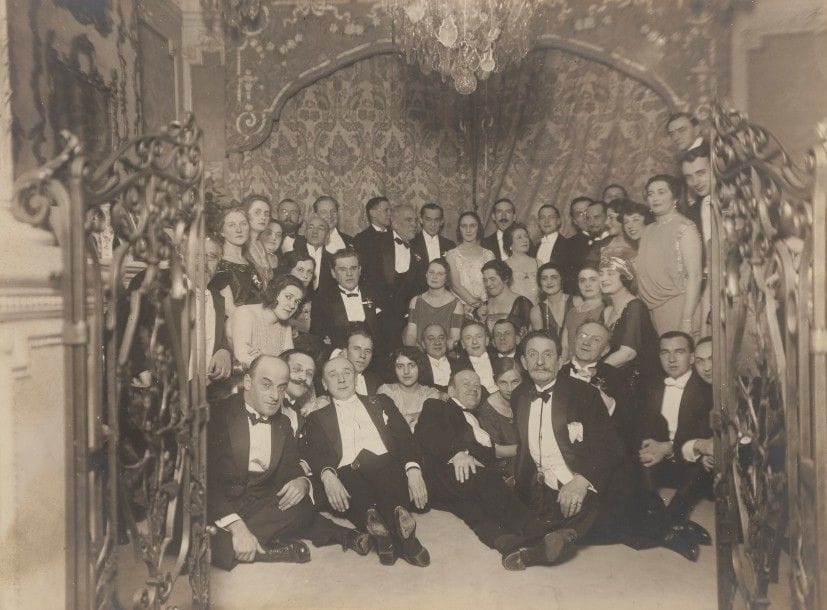 R. SOBOL. Paris.
La troupe du Théâtre artistique de Moscou chez Madame d’Erlanger. 22 décembre 1922.
Timbre à sec du photographe en bas à droite sur le support. Annoté au dos et daté.
16,5 x 22 cm
On y joint deux tirages argentiques par Isabey. Il s’agit sans doute d’une photographie prise à l’occasion de la tournée de la troupe à Paris.

Tamara Erlanger (? - 1953). Chorégraphe. Elle fonde en 1926 avec son mari Théodore et Alexandre Volinine l’Académie d’art chorégraphique dans leur hôtel particulier au 132 avenue de Villiers.

Р. СОБОЛЬ (R. SOBOL). Париж.
Труппа Московского Художественного Театра в Париже в гостях у Тамары Яковлевны Эрлангер. 22 декабря 1922 г.
Тиснение фотографа снизу справа. На обороте аннотация и дата.
16,5 х 22 см
Т. Я. Эрлангер (Эрланже) (? – 1953). Хореограф. Жена Ф.А. Эрлангера. Основала вместе с мужем и А. Волининым Академию хореографического искусства (1926) в собственным особняке по адресу 132 авеню де Вилье.
Две серебряные фотографии Изабэ (Isabey). По всей вероятности, фотографии сняты в время гастролей труппы МХАТа в Париже.
16 х 22 см