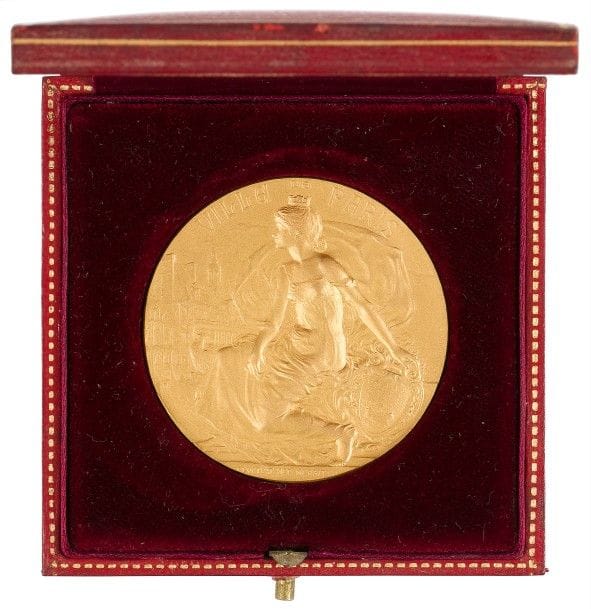 Graveur Georges-Henri PRUD’HOMME
Médaille en or. Avers : Ville de Paris. La ville personnifiée par une femme portant une couronne murale de commune est assise la main posée sur un écu aux armes de la ville. A gauche un coq et en arrière-plan, l’Hôtel de Ville. En exergue la devise de la ville. 
Revers : inscription sur 8 lignes : « Département de la Seine. Concours/de véhicules/industriels - Ministère de la Guerre - Automobile club/de France - Prix de le ville de Paris – 1909 ». 
Dans son écrin d’origine recouvert de cuir grainé bordeaux à filets dorés et frappé aux armes de la ville. 
Poinçons sur la tranche à 6 heures : or et corne d’abondance. 
Diamètre : 5 cm ; poids : 89 g