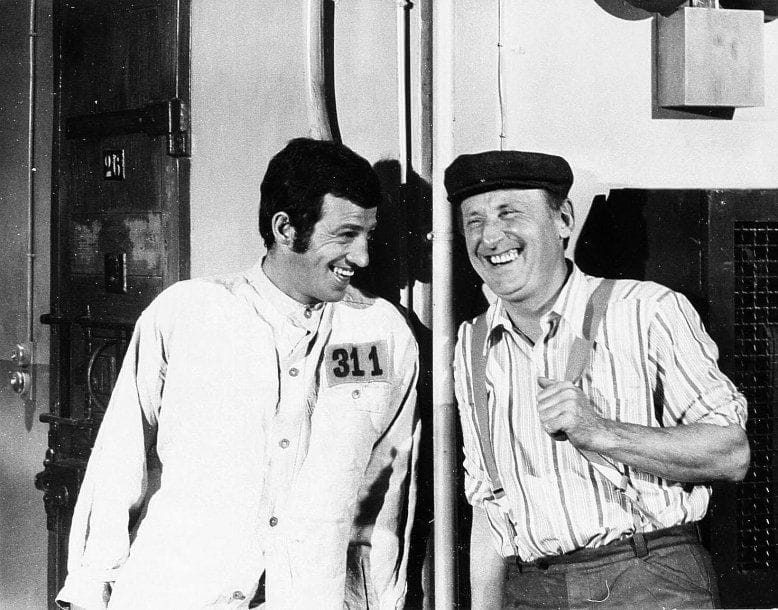 Le cerveau, 1969. De Gérard Oury, avec Jean-Paul Belmondo, Bourvil et David Niven. 11 tirages argentiques d'époque. Tampon de presse APIS aux versos. 27 x 21,5 cm. On joint un document tapuscrit.