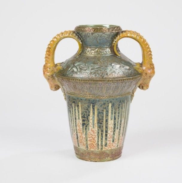 Travail Art Nouveau 
Bouquetins 
Vase amphore à deux prises latérales zoomorphes. Épreuve en céramique au riche décor, de feuilles de lierre et frises végétales stylisées, émaillé polychrome irisé et or, en partie en relief. Restaurations au prises, petits éclats et sauts d’émail à la base. Daté 1918 sous la base. H. : 30 cm 