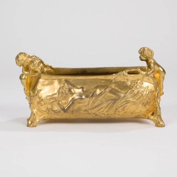 Charles KORSCHANN (1872-1943) 
Nymphe alanguie 
Jardinière de table quadripode. Épreuve en bronze doré à décor en relief et en ronde-bosse de personnages parmi la végétation. Au dos décor d’un paysage incisé et en léger relief. Signée KORSCHANN Paris au dos, marquée du cachet du fondeur LOUCHET sous la base. 13,5 x 26 x 11 cm 