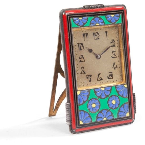 WEGELIN Fils - Genève
Pendulette à chevalet. Épreuve en argent émaillé polychrome, l’arrière et le chevalet en laiton. Époque Art Déco, circa 1925. Un infime choc sur la bande émaillée rouge de la base. Marquée WEGELIN Fils en bas à gauche sur le cadran, porte le numéro 3685 et les poinçons de garantie et d’un Maître Orfèvre (non identifié) sur l’arrière. 10,4 x 6,7 cm 
Poids brut : 302 g