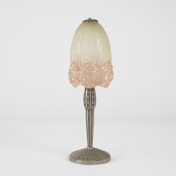 MULLER Frères Lunéville & TRAVAIL ART DÉCO 
Hortensia
Petite lampe de table. Fût cannelé et perlé en métal argenté. Abat-jour en verre moulé et, en partie basse, émaillé rose. Signée MULLER Fres Lunéville sur la verrerie. H. : 34,5 cm 