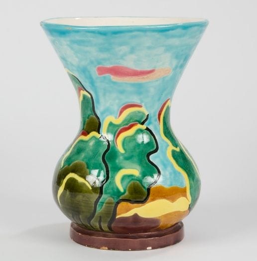 Claude RENOIR (1901-1969) 
Paysage arboré 
Vase bursaire sur talon à large col évasé. Épreuve en faïence émaillée polychrome. Intérieur émaillé blanc cassé. Usures d’émail à l’ouverture et éclats au talon. Signé Claude RENOIR France et numéroté C 125 sous la base. H. : 28,5 cm 