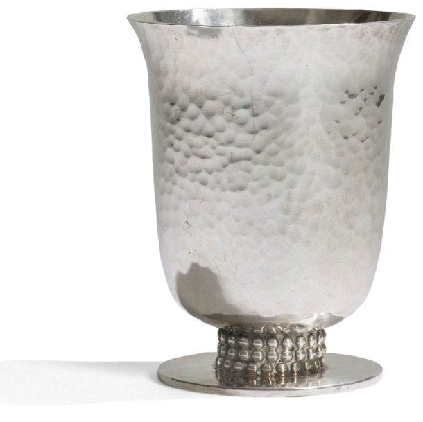 Jean DESPRÉS (1889-1980) 
Grande timbale formant petit vase en métal argenté à surface martelée. Le pied reçoit une triple rangée perlée et repose sur une base circulaire. Signée J. DESPRÉS à la pointe sous la base. H. : 9,5 cm (Provenance : Ancienne collection de Madame R. née à Avallon, œuvre acquise directement auprès de l’artiste).