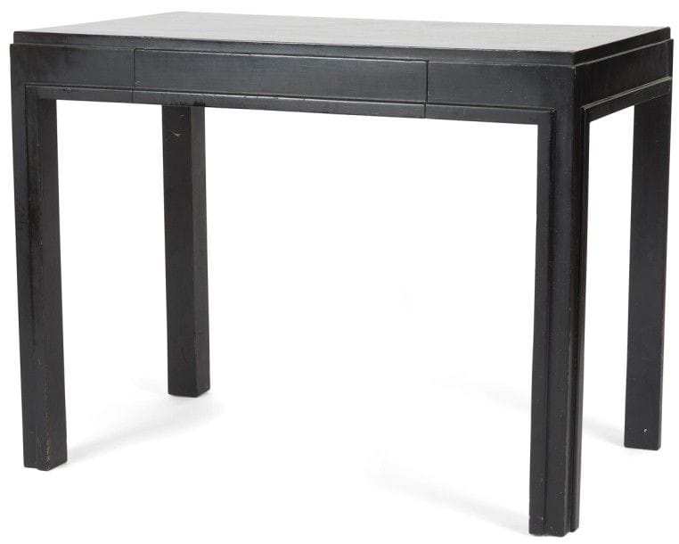 TRAVAIL DES ANNÉES 1930/40 
Table à écrire moderniste en bois (re)noirci. L’entablement, ouvrant par un tiroir en ceinture, repose sur quatre pieds d’angle. Un jonc achève les arêtes intérieures de chacun des pieds et se poursuit sous la ceinture. 75 x 58 x 98 cm