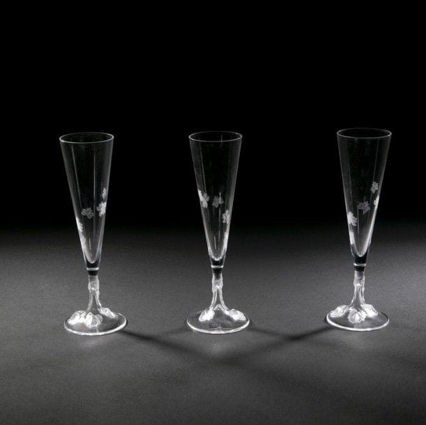 Maison LALIQUE 
Vigne
Suite de 3 flûtes à Champagne. Épreuves en cristal soufflé-moulé et, en partie, satiné. Chacune dans son coffret d’origine. Chacune signée LALIQUE®France à la pointe sous la base. 
H. : 25,5 cm