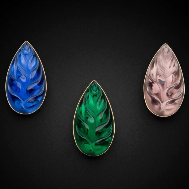 Maison LALIQUE d’après un modèle de Marie-Claude LALIQUE (1935-2003)
Héliconia
Suite de trois broches en métal doré et verre parme, vert et bleu. Chacune signée LALIQUE France au revers. L. : 5,5 cm