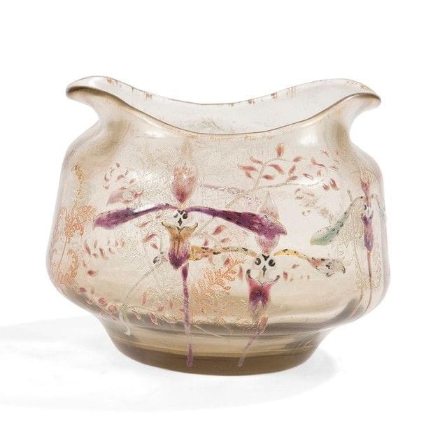 Émile GALLÉ (1846-1904)
Orchidées, fougères et graminées
Vase bursaire sur talon à col mouvementé à chaque extrémité.
Épreuve en verre fumé au décor tournant émaillé polychrome, les fougères traitées en gravure et patinées en couleur ou à l'or.
Col frotté à l'or.
Signé à l'orchidée et Émile GALLÉ à Nancy - Déposé sous la base.
Hauteur : 9,5 cm
Longueur : 11 cm