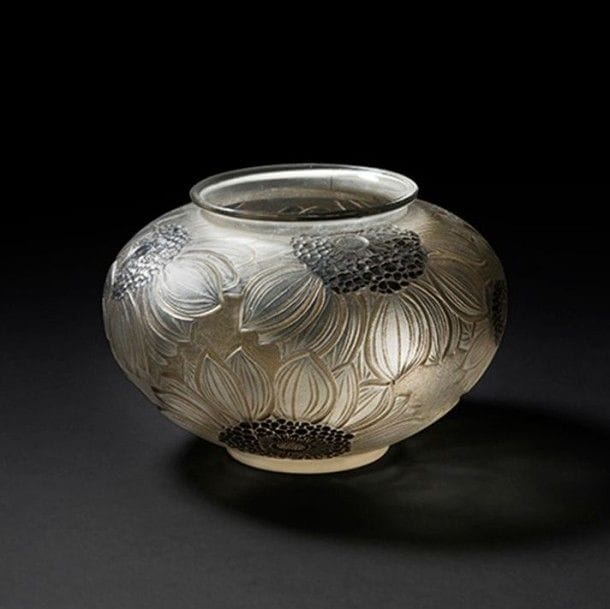 René LALIQUE (1860-1945) 
Dahlias, modèle créé en 1923, supprimé du catalogue en 1937 et non repris après 1947
Vase balustre sur talon et à col ourlé (réf. Marcilhac 938).
Épreuve en verre très légèrement fumé soufflé-moulé patiné et, en partie, émaillé.
Patiné gris d'origine.
Signé R. LALIQUE sous la base.
Hauteur : 12,3 cm