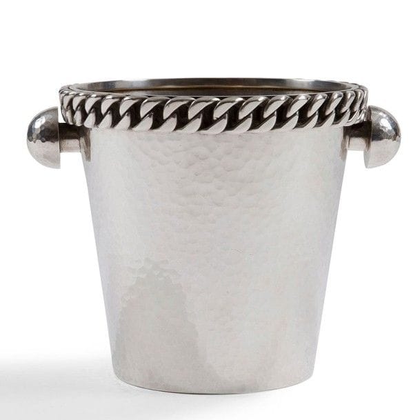 Jean DESPRÉS (1889-1980)
Seau à champagne moderniste en métal argenté.
Le corps à surface martelée reçoit deux prises en demi-sphère sur entretoise, également martelées, et accueille une épaisse gourmette à maillons plats en pourtour de la bordure.
Le col est doublé, sur son intérieur, d'un ressaut.
Signé J. DESPRÉS à la pointe, porte le poinçon de Maître Orfèvre à deux reprises sous la base.
Hauteur : 19,5 cm
Provenance :
Ancienne Collection M. & Mme F. (Guillon près d'Avallon - France), œuvre acquise par ceux-ci directement auprès de l'artiste.