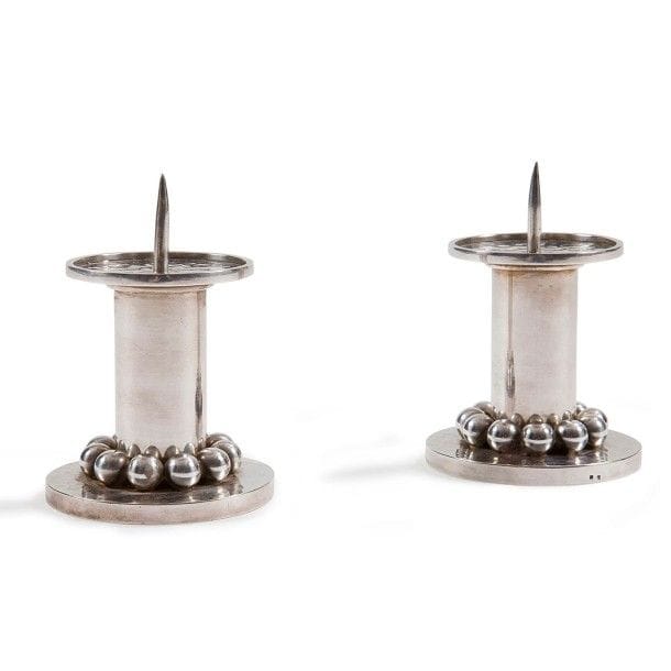 Jean DESPRÉS (1889-1980)
Paire de bougeoirs de table en métal argenté.
Les fûts cylindriques traités lisses reposent sur d'épaisses bases circulaires, à surface martelée, ornées chacune d'un rang tournant de sphères.
Les parties hautes sont constituées d'une platine circulaire à surface martelée et munie d'un pique porte-bougie.
Chaque œuvre est signée J. DESPRÉS à la pointe au revers et porte le poinçon de Maître Orfèvre à deux reprises sur la tranche de sa base.
Hauteur : 11 cm
Provenance :
Ancienne Collection M. & Mme L. (Thisy près d'Avallon - France), œuvres acquises par ceux-ci directement auprès de l'artiste.