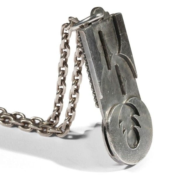 Jean DESPRÉS (1889-1980)
Pendentif double face et chaîne en argent.
Décor en applications, sur le pendentif, de motifs de forme libre sur fond martelé d'un côté et de doubles rangs perlés et du prénom Annette en application sur l'autre côté.
Signé J. DESPRÉS à la pointe sur le côté du pendentif et porte les poinçons de Maître Orfèvre et de garantie sur un des anneaux de la chaîne.
Poids : 93,30 g
Provenance :
Ancienne Collection M. & Mme X. (Avallon - France), œuvre acquise par ceux-ci directement auprès de l'artiste.
