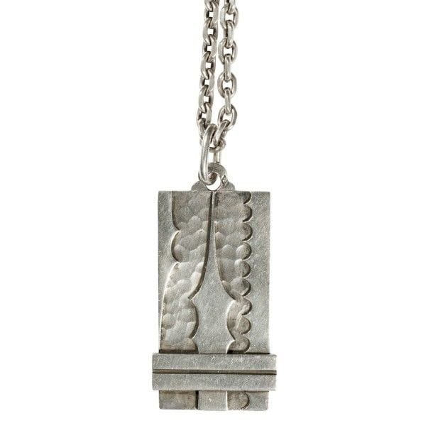 Jean DESPRÉS (1889-1980)
Pendentif moderniste en argent.
Décor en applications, sur le pendentif, de motifs de forme libre et de barrettes sur fond martelé d'un côté
Vendu avec sa chaîne d'origine.
Signé J. DESPRÉS à la pointe à l'arrière du pendentif et porte les poinçons de Maître Orfèvre et de garantie sur l'anneau et le pendentif.
Poids : 90 g
Provenance :
Ancienne Collection avallonaise de M. & Mme X., œuvres acquises par ceux-ci directement auprès de l'artiste.

