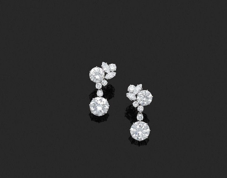 Paire de motifs d’oreilles en platine et or gris 18K (750‰) représentant une fleur stylisée, chacun serti de diamants de taille brillant pesant respectivement 2,02 et 1,97 ct agrémentés de diamants plus petits, retenant en pampille amovible un diamant de taille brillant pesant respectivement 4,17 et 4,01 cts. Poinçon de maître ayant travaillé pour la Maison Boucheron. Dans un écrin de la Maison Boucheron. 
Haut. : 3 cm environ. 
Poids brut : 11 g 
Les diamants accompagnés chacun d’un rapport LFG attestant selon son opinion : 4,17 cts couleur D, pureté VVS1 ; 4,01 cts couleur D, pureté VVS1 ; 
2,02 cts couleur F, pureté VS1 ; 1,97 ct couleur F, pureté VVS2