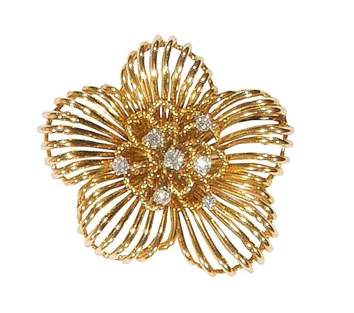 Broche fleur en or jaune 18K (750‰), en fils lisses et torsadés, le pistil serti de diamants sur platine. 
Travail des années 1950. 
Dimensions : 3,8 x 3,5 cm environ. 
Poids brut : 23,4 g